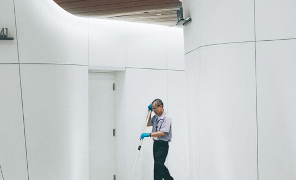 Cleaning professional in bright hallway